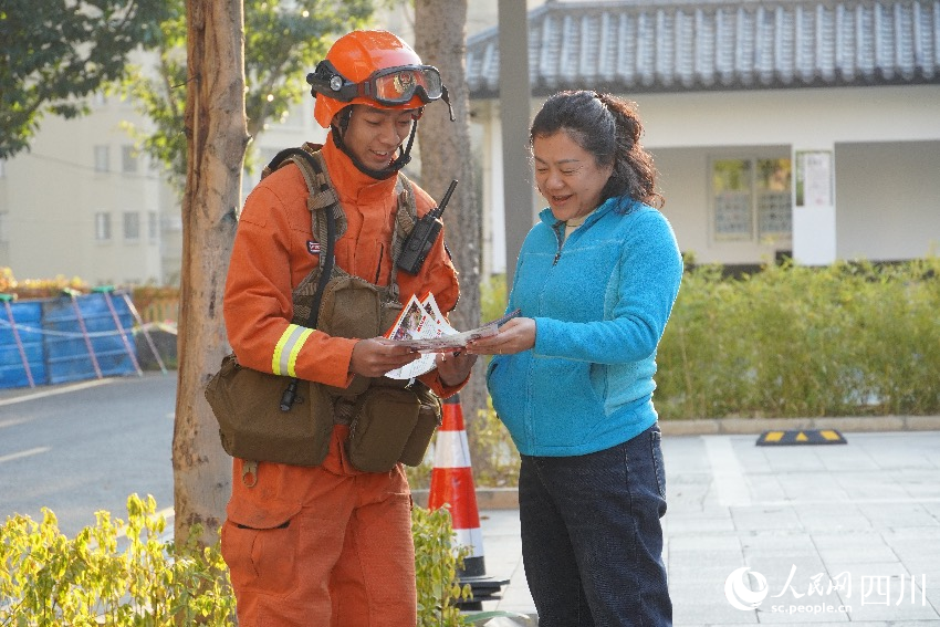 12月30日，在四川攀枝花东华山城市之眼，流动宣传员为游客讲解森林防火知识。羊冉摄