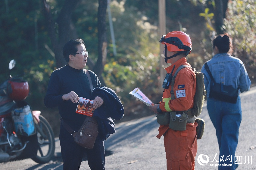 12月30日，在四川攀枝花东华山城市之眼，流动宣传员为游客讲解森林防火知识。羊冉摄