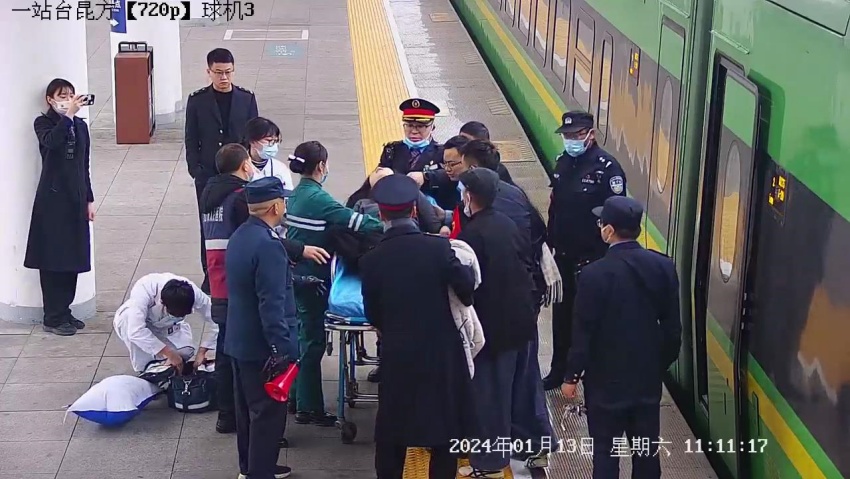 工作人员协助医护人员将旅客送上救护车。中国铁路成都局集团有限公司供图