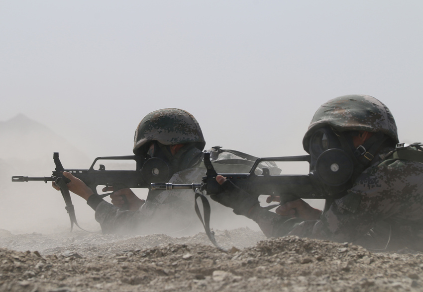 甘建超（右一）在进行火力突击训练。广安市退役军人事务局供图
