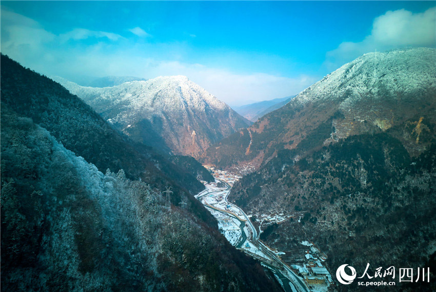 蓝天、雪山、村寨相映生辉。胡宇摄