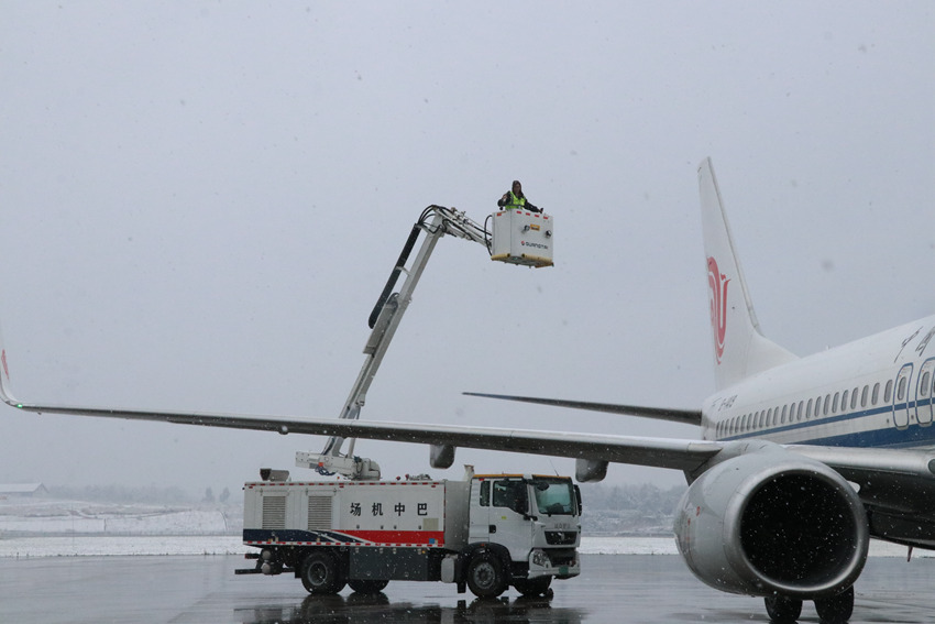 巴中机场，工作人员在雪中喷洒除冰液。四川机场集团供图