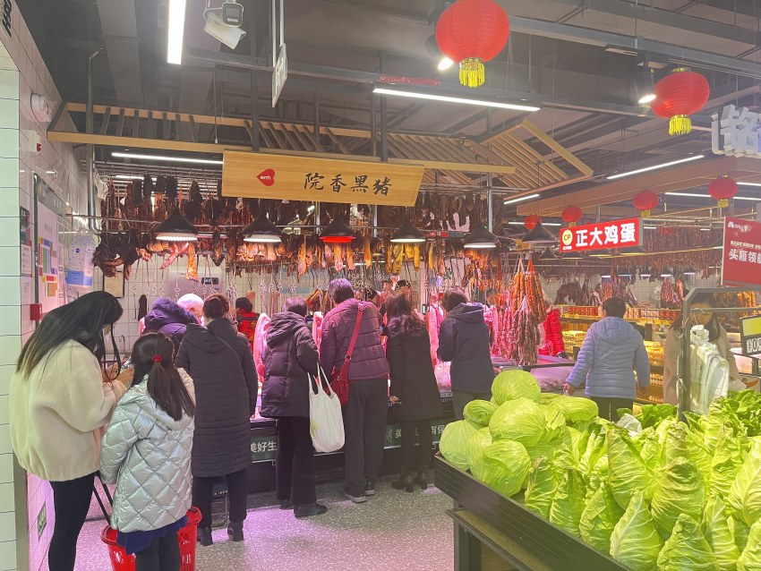 益民菜市东苑店内，市民正在买菜，摊点上摆满了蔬菜。益民菜市供图