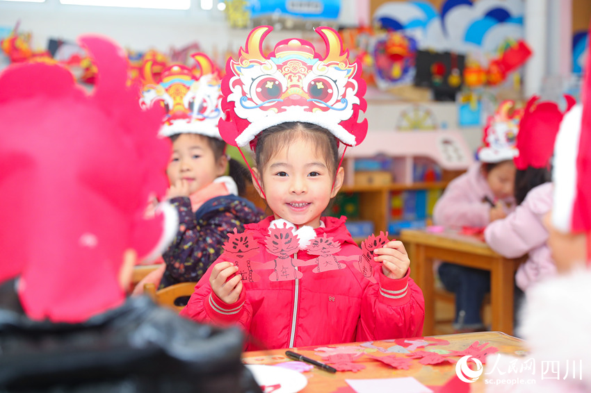 幼儿园小朋友展示亲手制作的窗花。牟科摄