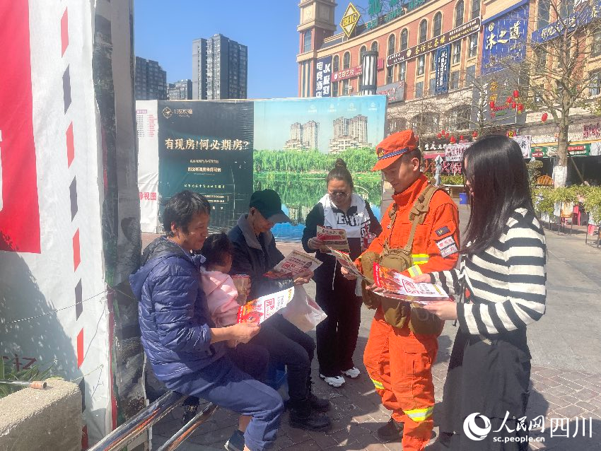 2月10日，在四川攀枝花消防员李明挺与妻子熊一档一起正在发放防火宣传单。羊冉摄
