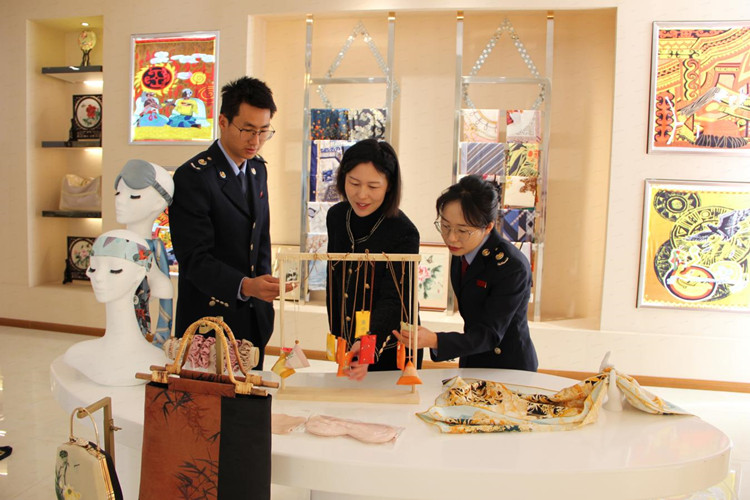 稅務干部了解生絲產品銷售情況。涼山州稅務局供圖
