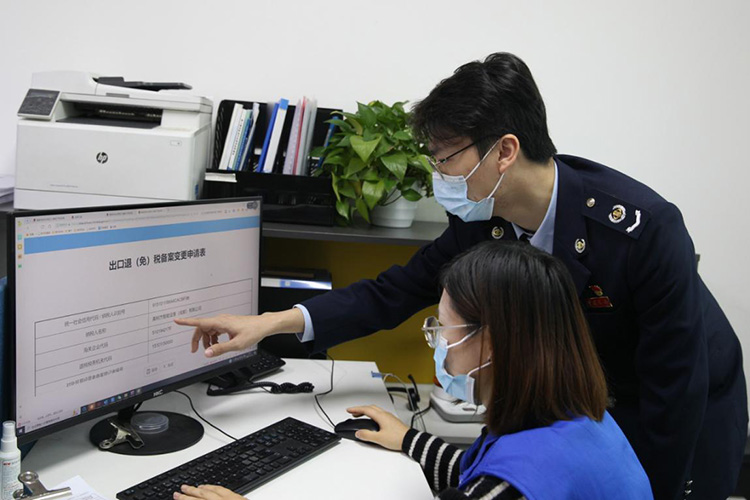 税务干部辅导出口企业完成无纸化管理申请。成都市税务局供图