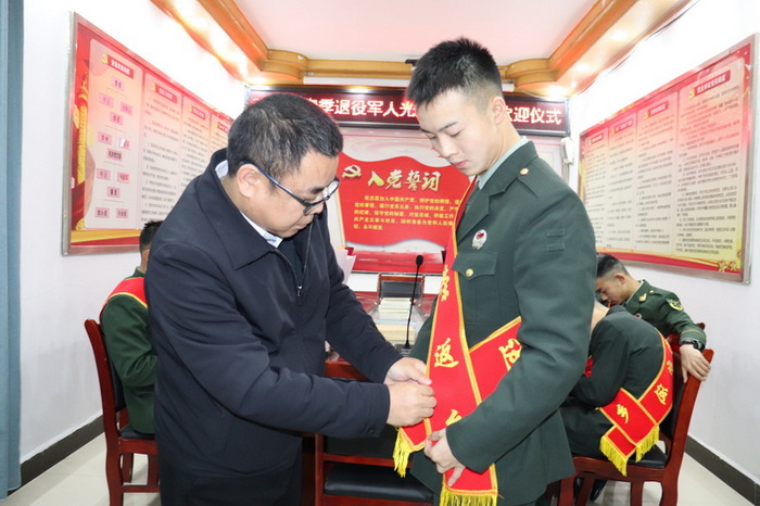 为退役士兵佩戴绶带和襟花。任玲摄