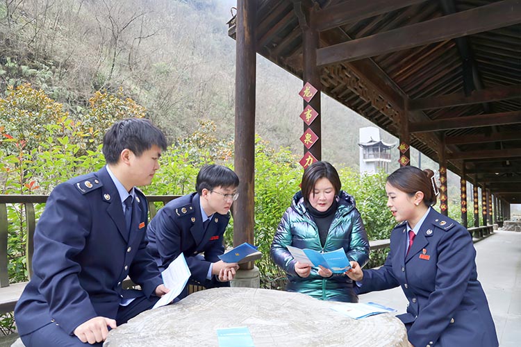 税务干部向胡晓玲宣传税收政策。达州市税务局供图