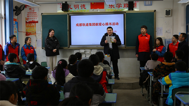 成都轨道集团青年志愿者为安乐乡九义中学同学们送书籍。成都轨道集团供图