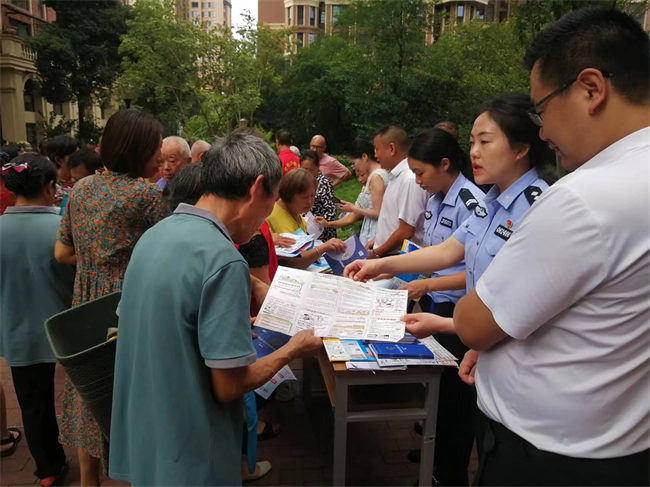 安岳縣公安局工業園派出所社區民警李新為社區居民發放科普傳單。圖片來源：資陽市公安局