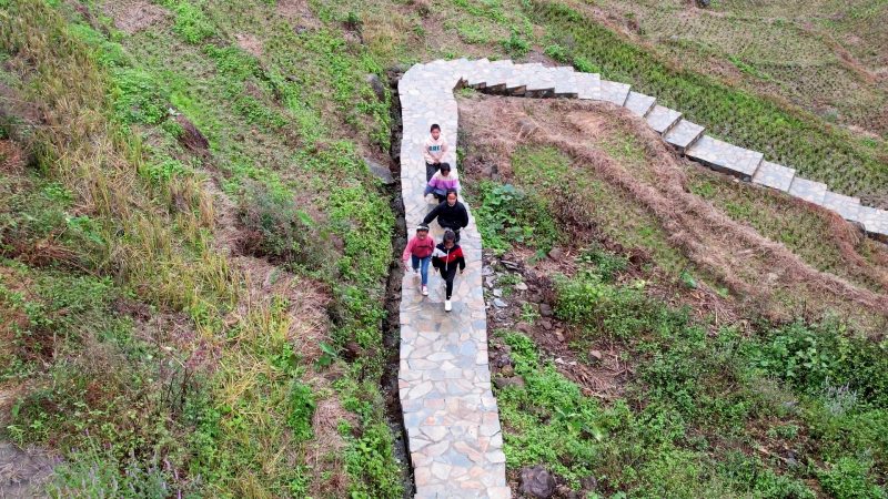 眉山村小学生行经绵竹帮扶修建的山间栈道上学。