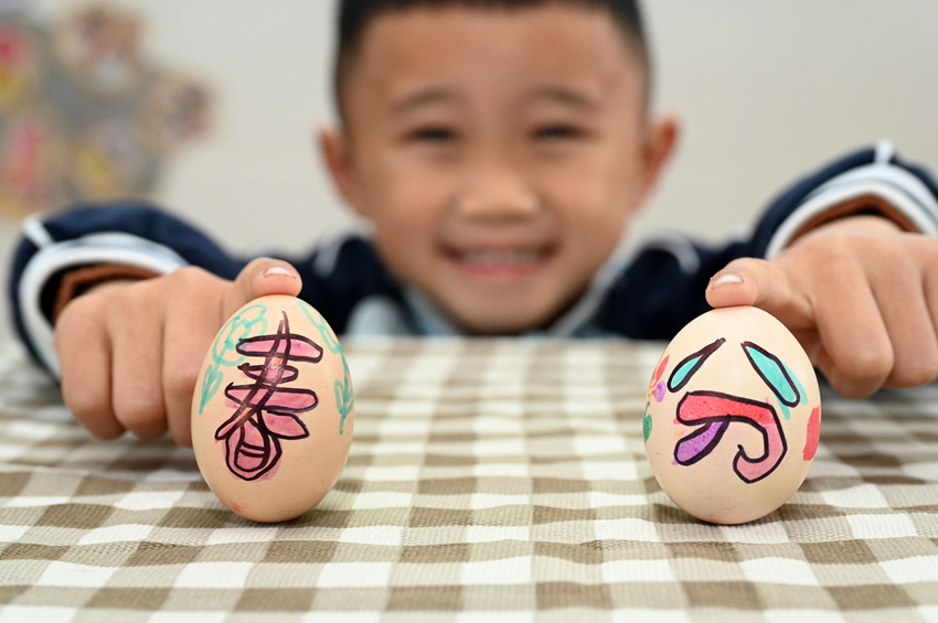 小朋友在老师带领下体验绘彩蛋和竖鸡蛋等传统习俗。兰自涛摄