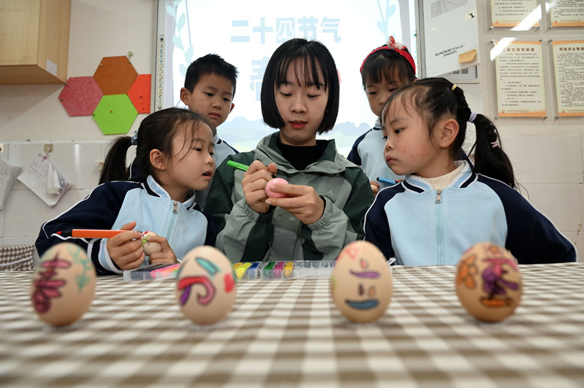 小朋友在老師帶領下體驗繪彩蛋和豎雞蛋等傳統習俗。蘭自濤攝