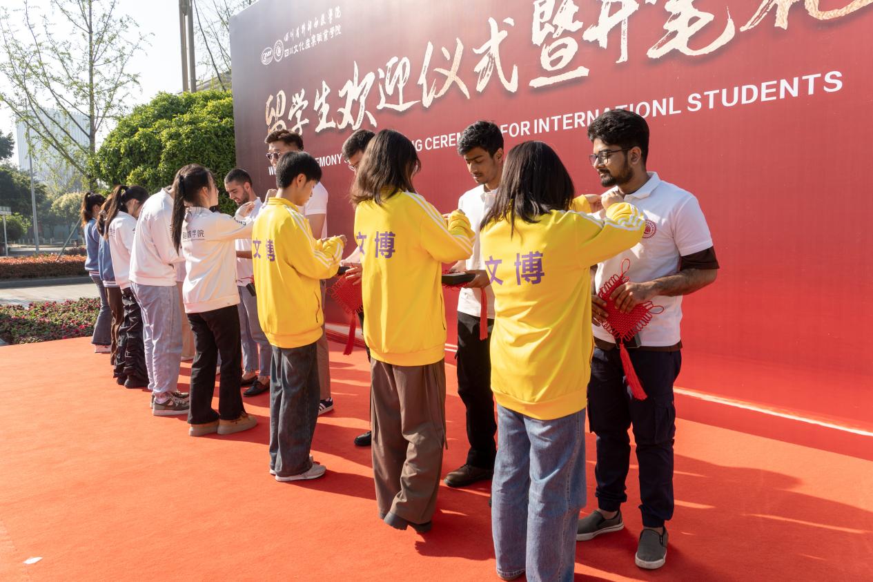 为留学生佩戴校徽并赠送学习礼品。四川文化产业职业学院供图
