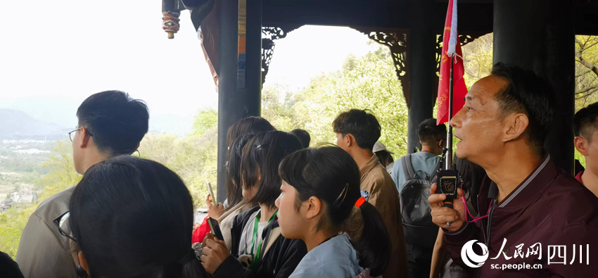 在都江堰秦堰楼，同学们一边听讲解一边观察。实习生 欧阳古月摄