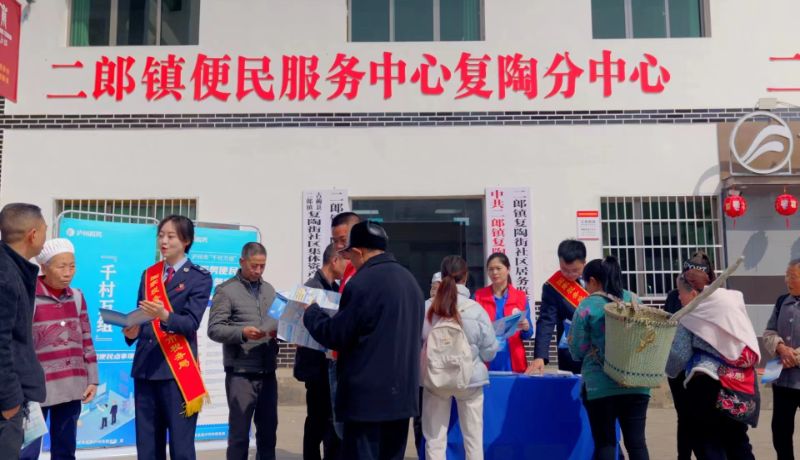 古蔺县税务局志愿者和“税费明白人”在古蔺县二郎镇复陶街社区宣传税费政策。蒲桂南摄