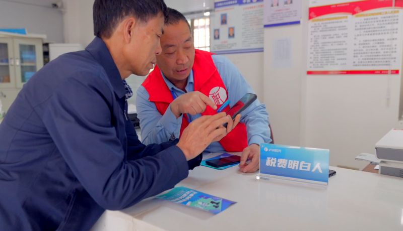 在泸县太伏镇永利村党群服务中心，“税费明白人”正在辅导缴费人通过手机缴纳社保费。蒲桂南摄