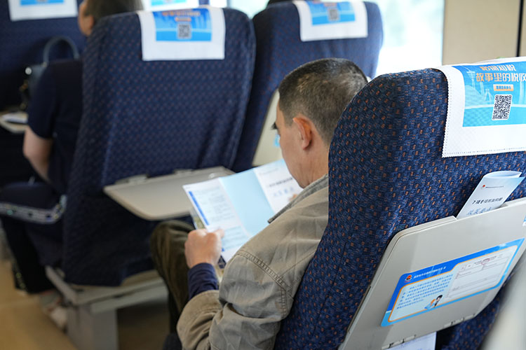 乘客正在看稅收宣傳資料。四川省稅務局供圖
