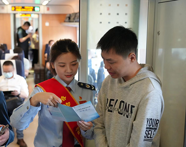 稅務干部在列車上向乘客宣傳稅收政策。四川省稅務局供圖