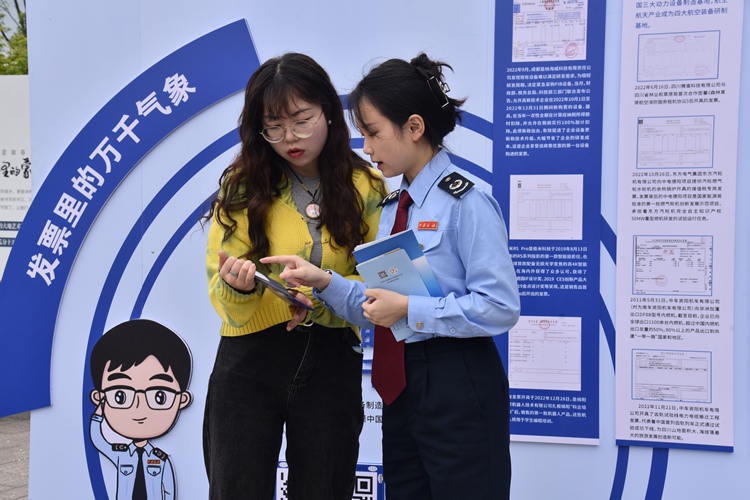 雅安市税务干部在流动税宣站为游客讲解手机办税操作流程。四川省税务局供图