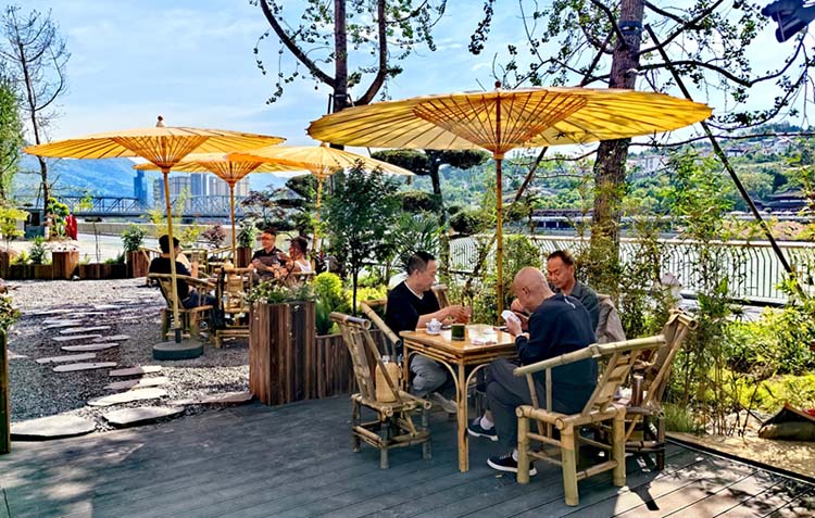 市民在提升后的江边喝茶聊天。陈平摄