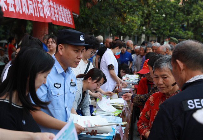 活动现场，荣县公安局经侦大队工作人员发放传单科普宣传。徐振宇供图 