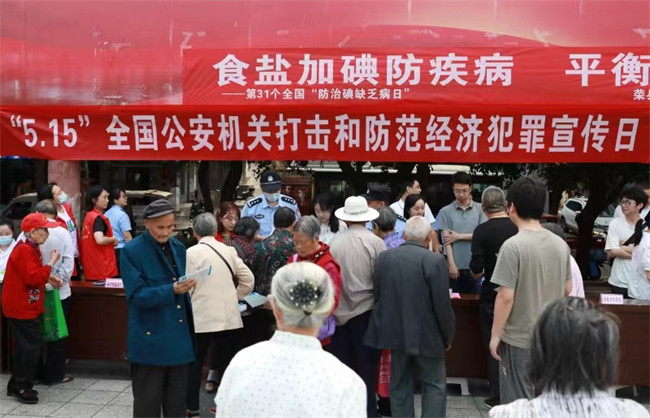 活动现场，荣县公安局经侦大队工作人员发放传单科普宣传。徐振宇供图 