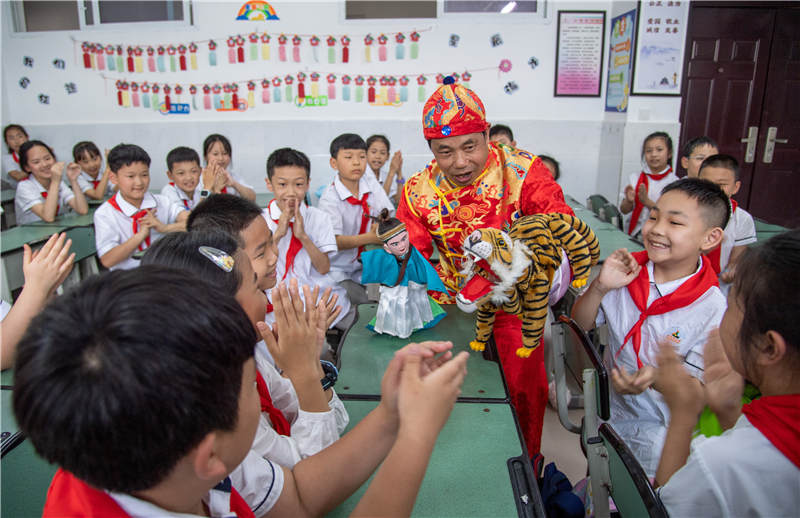 广安市广安区北仓路小学学生在校园内学习“非遗文化”手掌木偶戏。张国盛摄