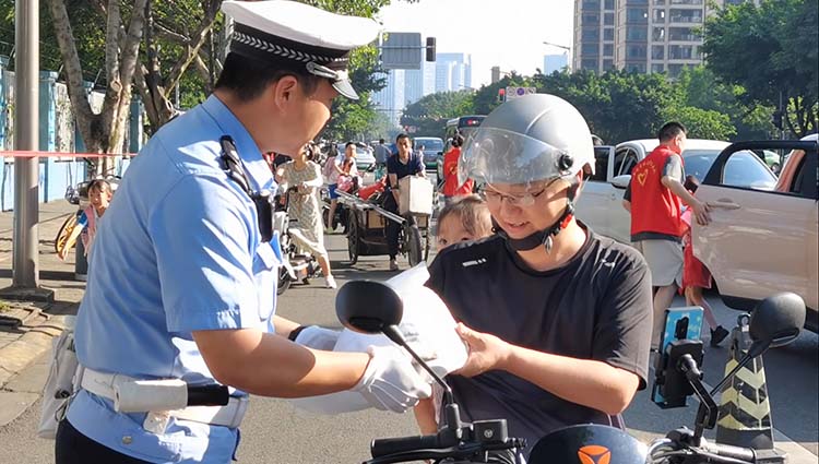 交警向家長宣傳戴頭盔的安全作用。成都交警四分局供圖