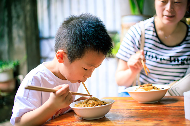 一位小朋友正在吃利州獨特美食“熱涼面”。利州區委宣傳部供圖