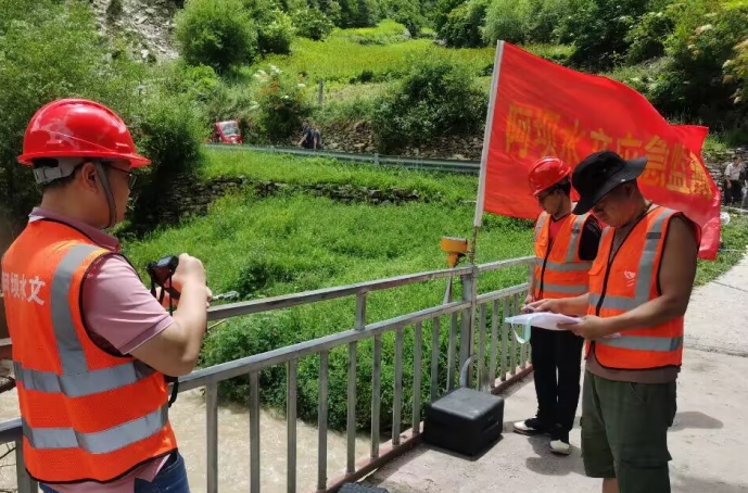 应急监测人员正在采集现场影像资料、安装水位计和流量测验。阿坝水文中心供图