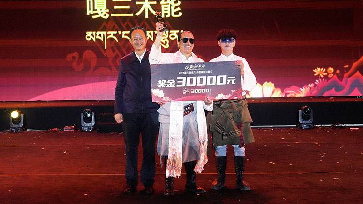 為獲獎歌手頒發獎金。紅原縣委宣傳部供圖