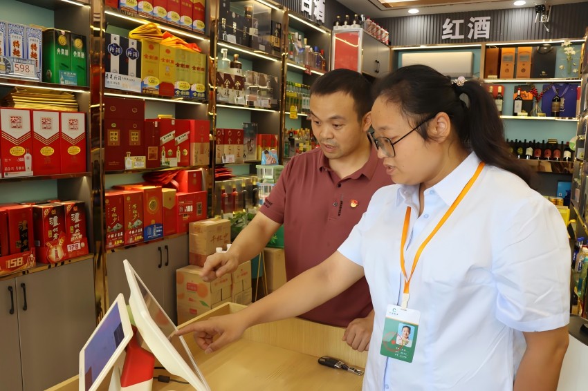 客户经理张晋指导张国洪使用智慧收银机。韩俊娇供图