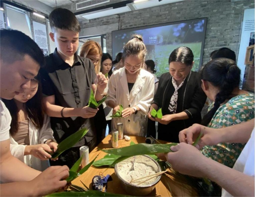 2024年端午节，广安职业技术学院党委书记王冬霞在指导留学生包粽子。广安职业技术学院供图