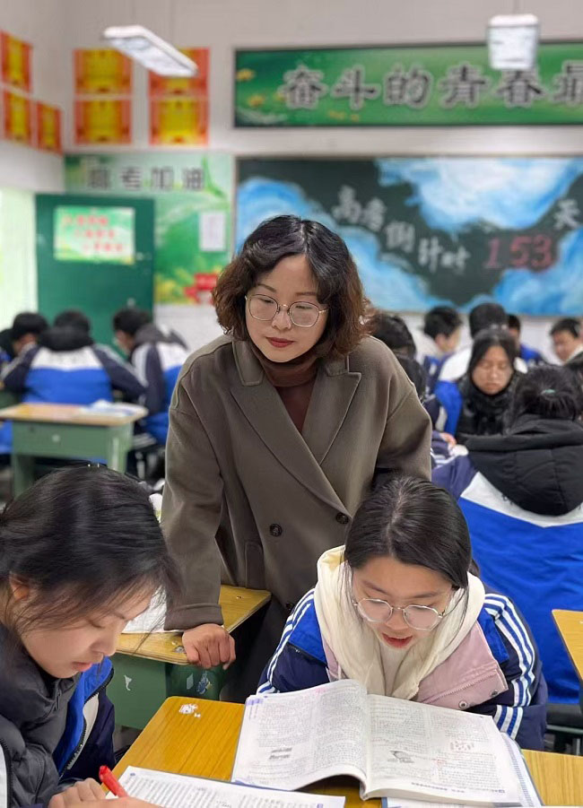 正在指导学生功课的王晓燕。曾莉供图