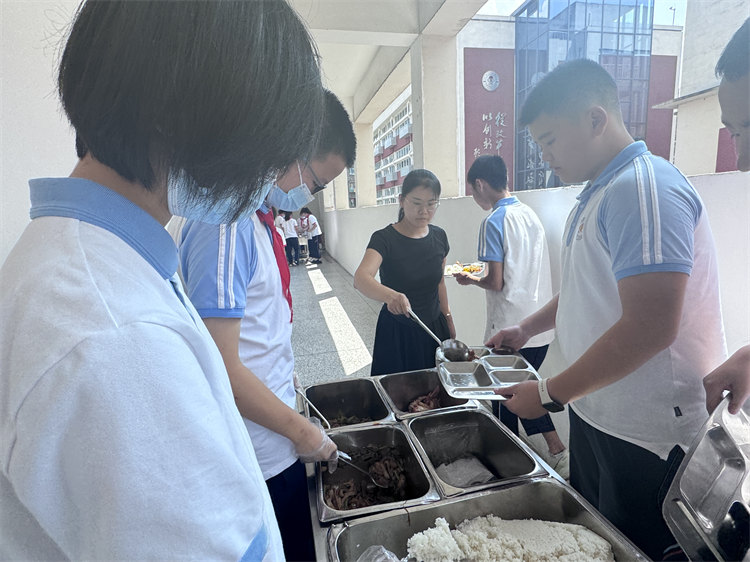 桑玉艷幫學生們打飯。青羊區教育局供圖