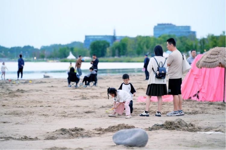 小朋友在兴隆湖畔玩海沙。天府新区融媒体中心供图