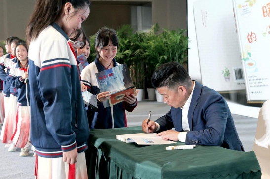 王永忠为学生签名送书。主办方供图