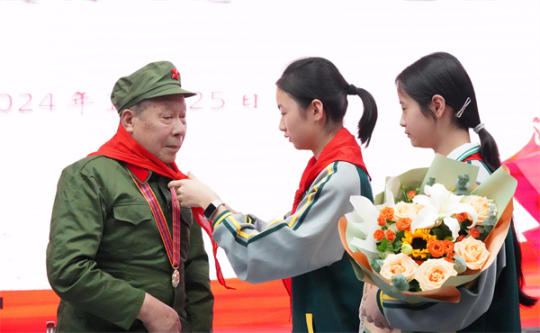 少先队员为冯学银佩戴红领巾。自贡市退役军人事务局供图