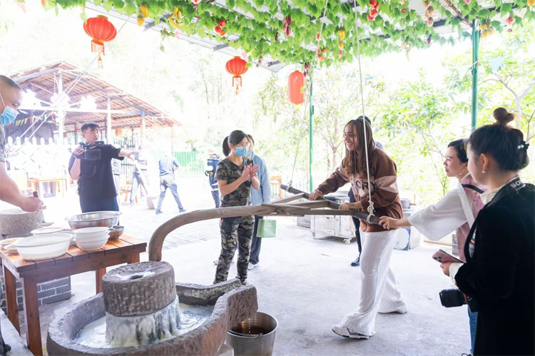 蒙達爾紀市森林中學學生代表體驗磨豆漿。中共廣安市委宣傳部供圖