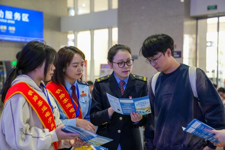 税务干部和铁路工作人员一起向乘客宣传开具电子发票业务。成都市税务局供图