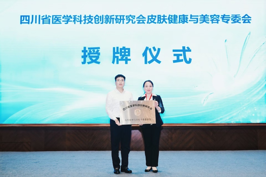 四川省医创会秘书长李小明为当选皮肤健康与美容专委会主任委员、成都市第二人民医院皮肤科冯燕艳颁发聘书。主办方供图
