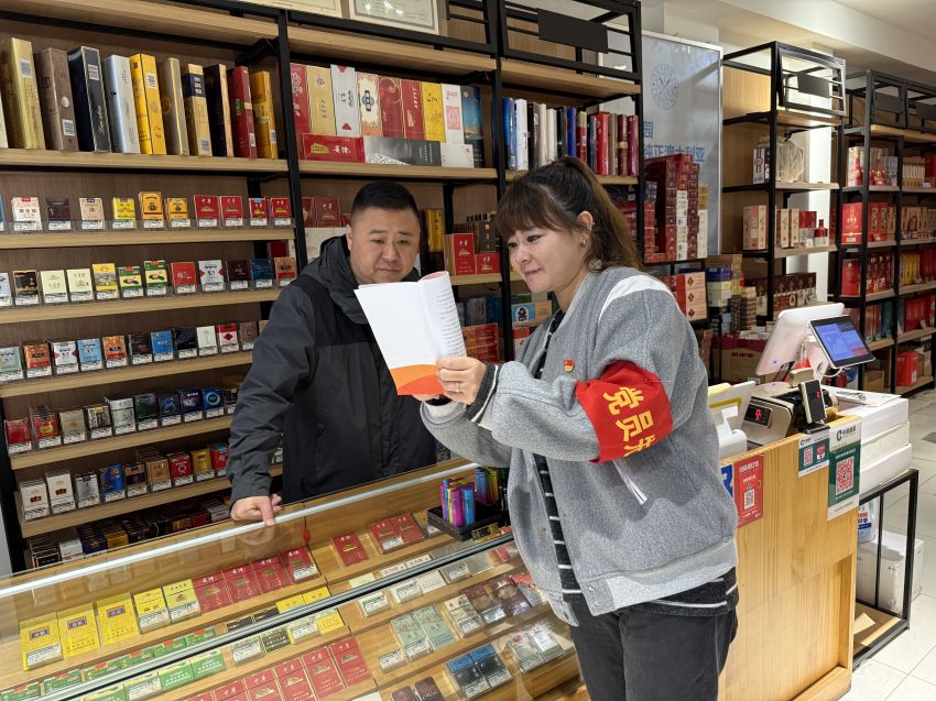 工作人员向零售户发放并讲解宣传材料。成都市新津区烟草专卖局（分公司）供图