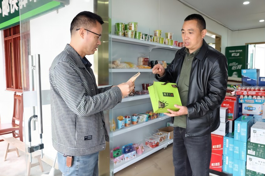 唐尚发向烟草客户经理熊畔红展示“保坪川茶”。牟宁玲供图