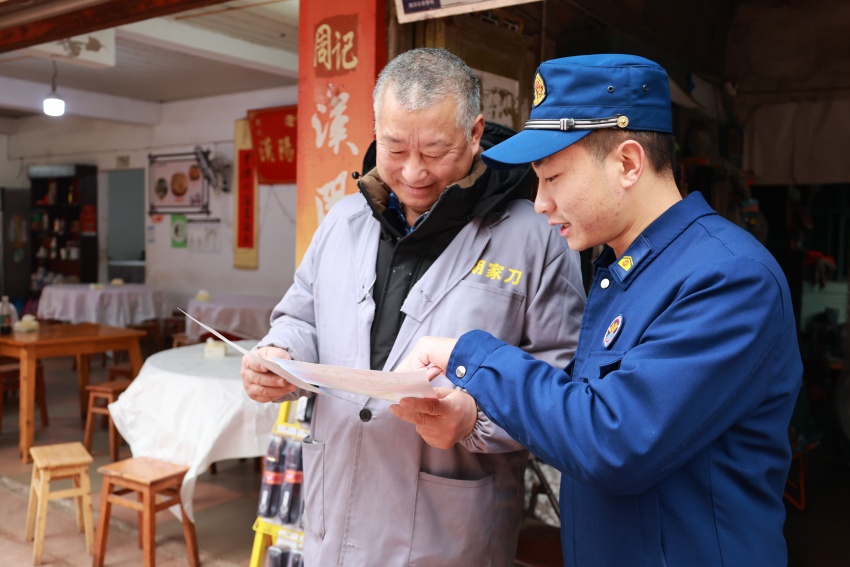 消防宣传员在乡镇商铺开展消防安全宣传。陈文旭摄