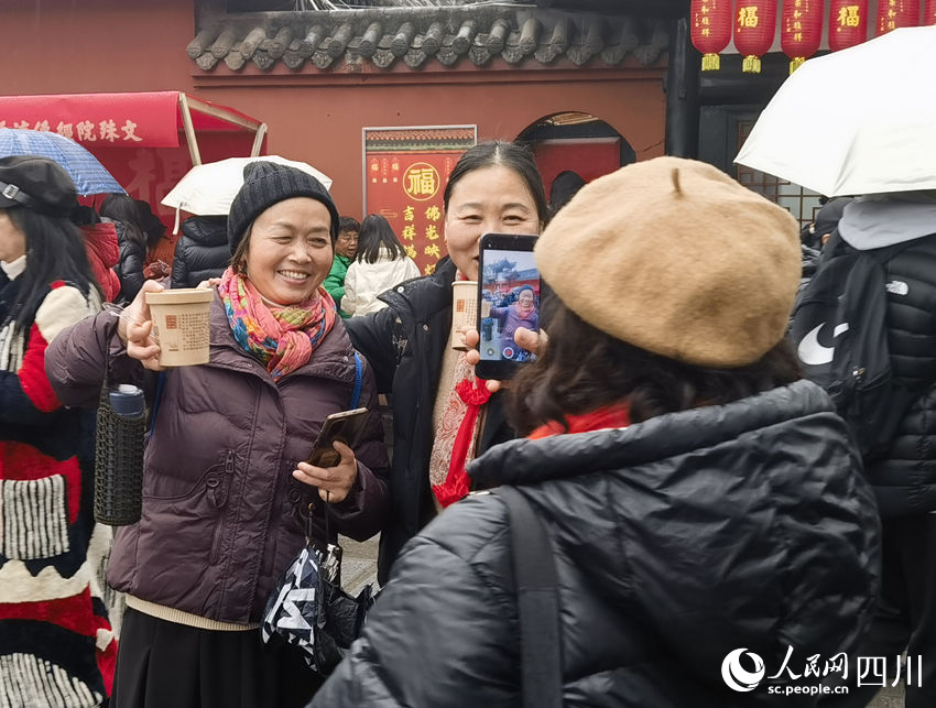 市民拍照展示领取到的腊八粥。实习生 冯子芯摄