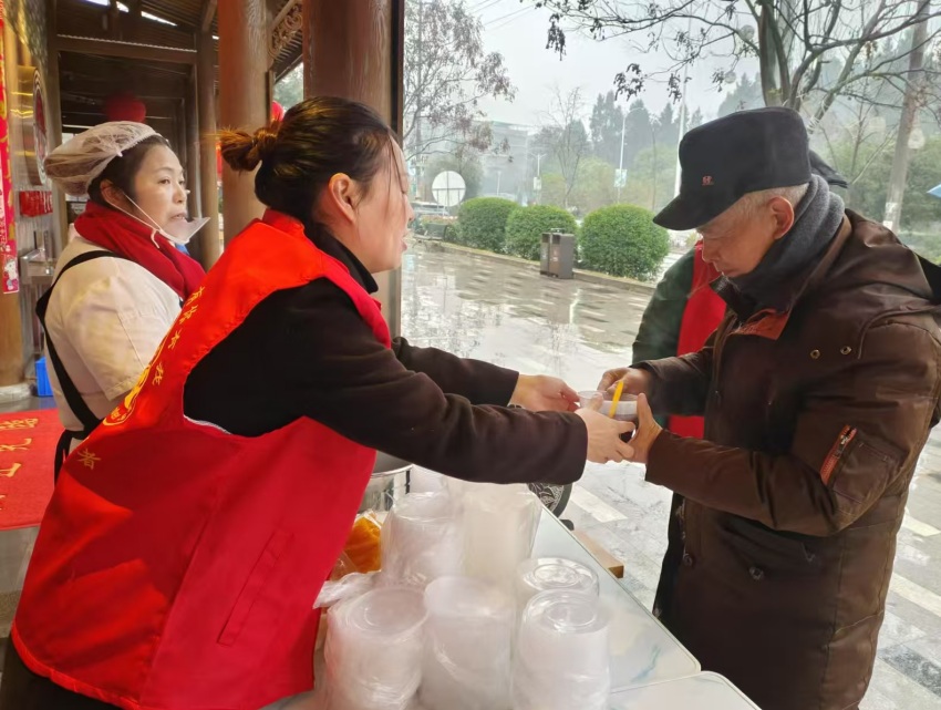 为老年人端上一碗热气腾腾的腊八粥。罗朴摄