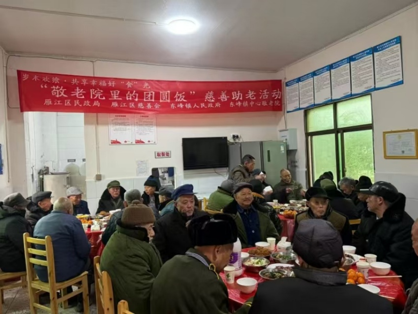 雁江区“敬老院里的团圆饭”慈善助老活动现场，老人们正围坐在一起吃团圆饭。胡明贵供图