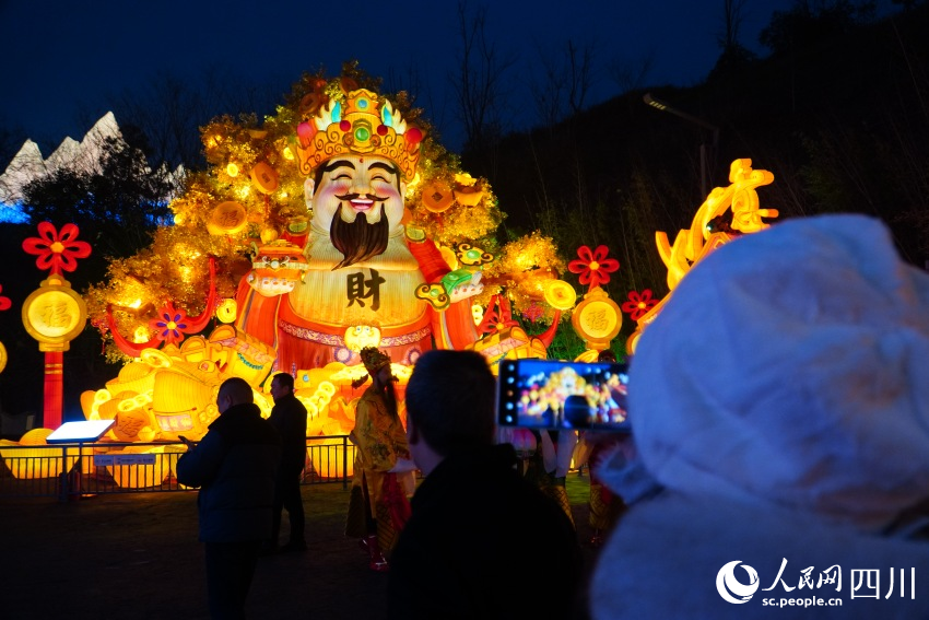 1月17日晚，游客在四川自贡中华彩灯大世界拍摄“喜迎财神”彩灯。人民网 赵祖乐摄